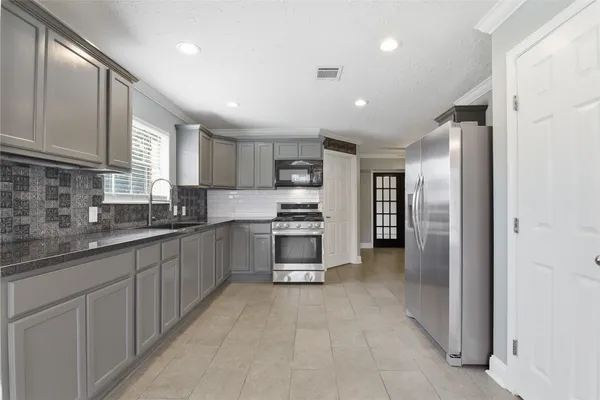 a kitchen with stainless steel appliances granite countertop a refrigerator and a sink