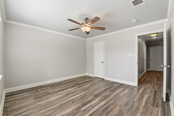 a view of an empty room with a window and wooden floor