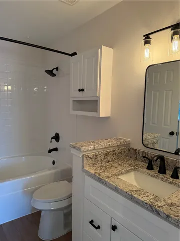 a bathroom with a granite countertop sink toilet and shower