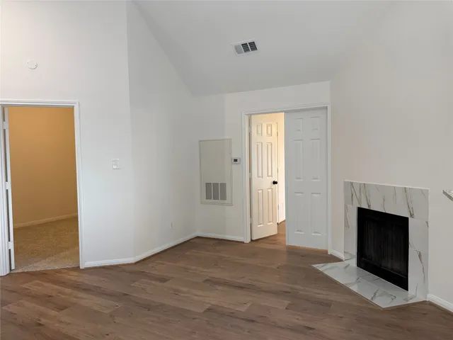 an empty room with wooden floor and fireplace