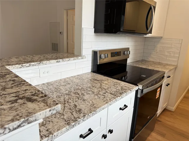a kitchen with stainless steel appliances granite countertop a sink stove and microwave