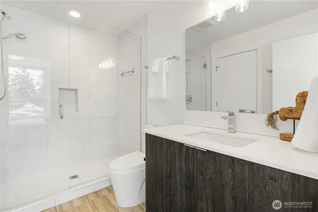 a bathroom with a sink a toilet and shower