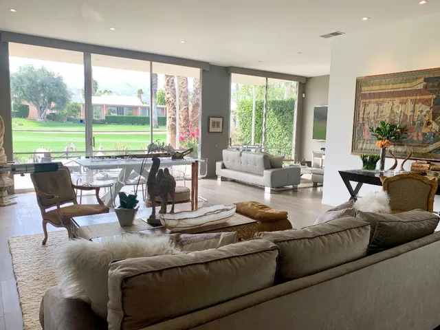 a living room with furniture and large windows