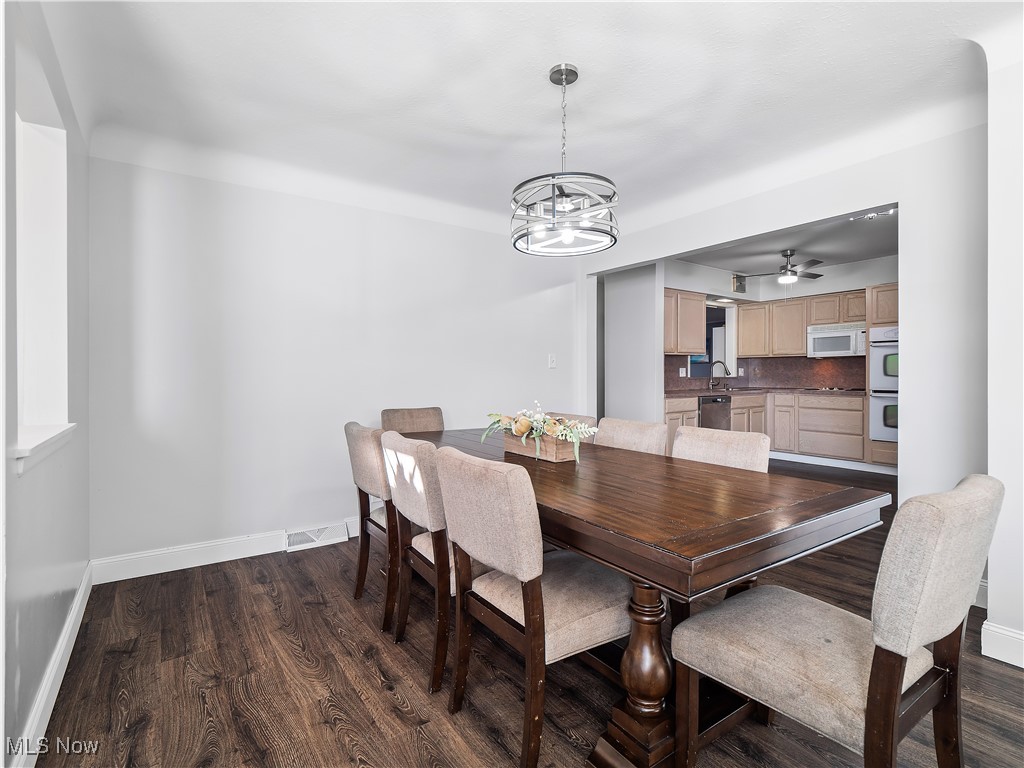 6377 Fairhaven Road Cleveland, OH 44124 - Photo 10 of 33 Dining room featuring ceiling fan with notable chandelier, dark hardwood / wood-style floors, and sink