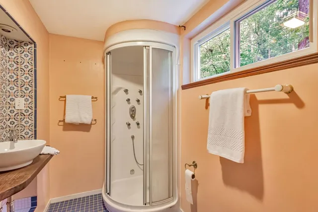 a bathroom with a granite countertop shower and a sink
