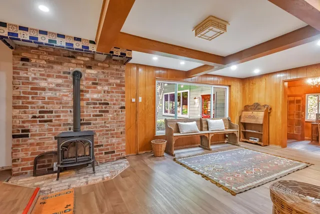 a living room with furniture a fireplace and wooden floor