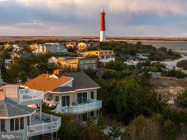 an aerial view of residential houses with outdoor space and ocean view
