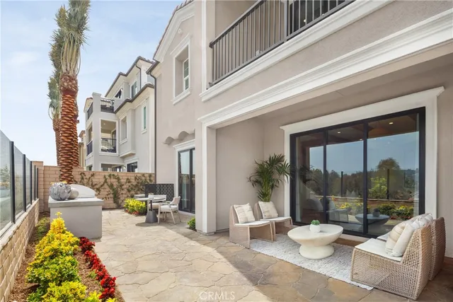 a view of a patio with couches table and chairs and potted plants