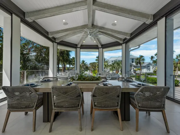 a dining room with furniture a chandelier and a large window