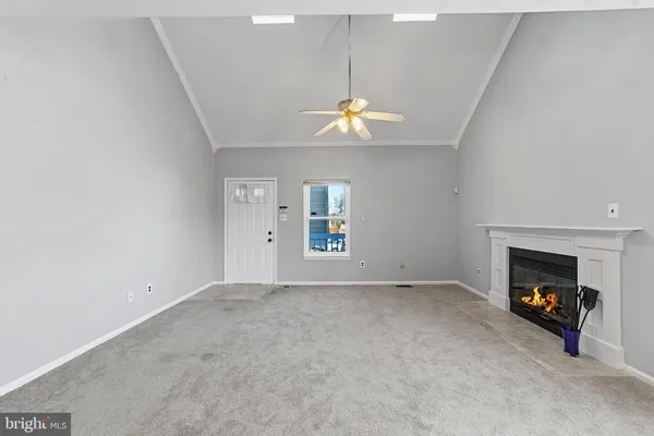 an empty room with windows and fireplace