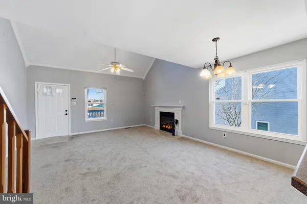 an empty room with windows and fireplace