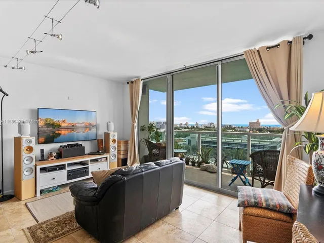 a living room with couch a flat screen tv and a floor to ceiling window