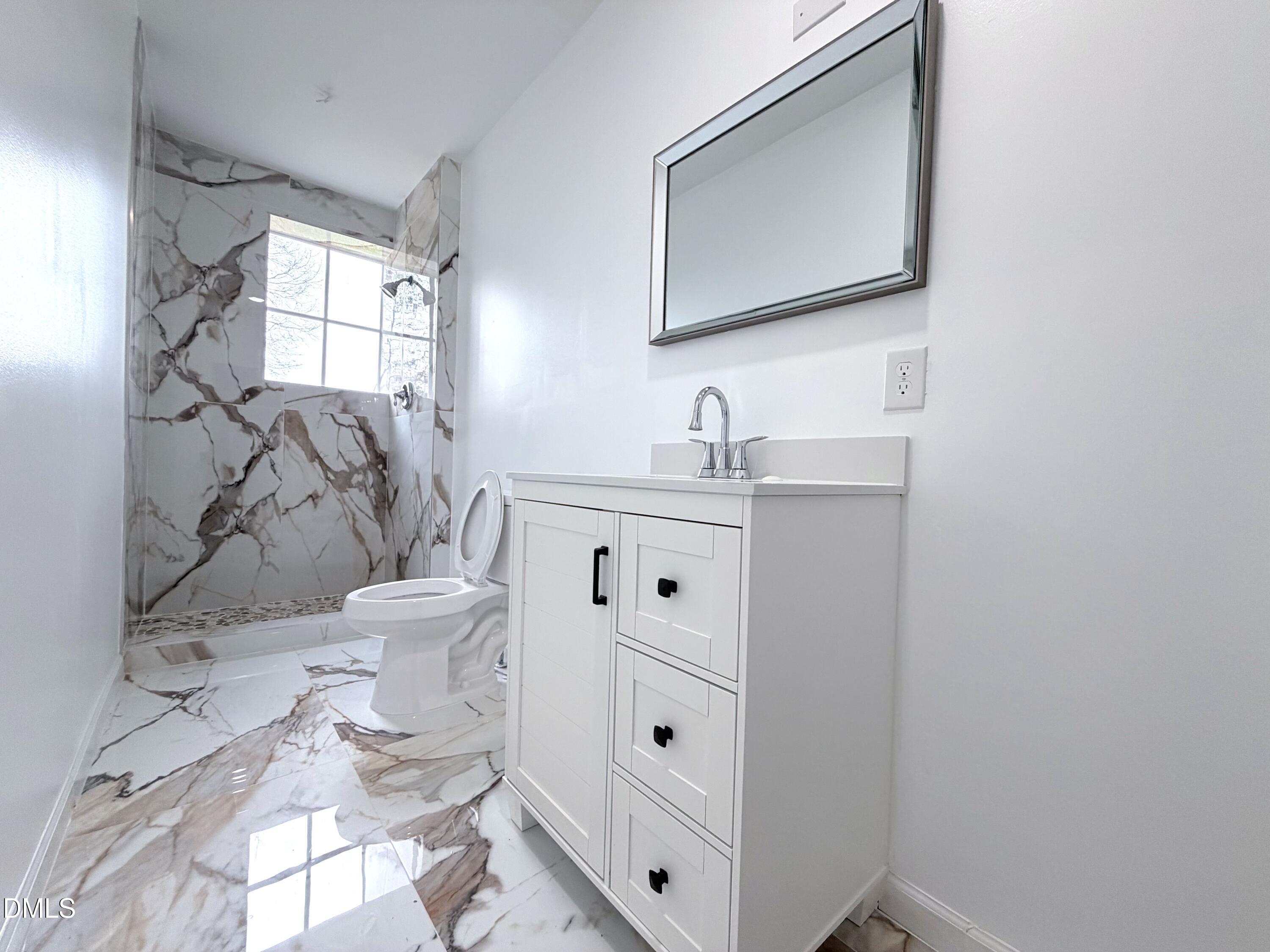 4408 Lee Street Ayden, NC 28513 - Photo 2 of 17 a bathroom with a toilet sink and mirror