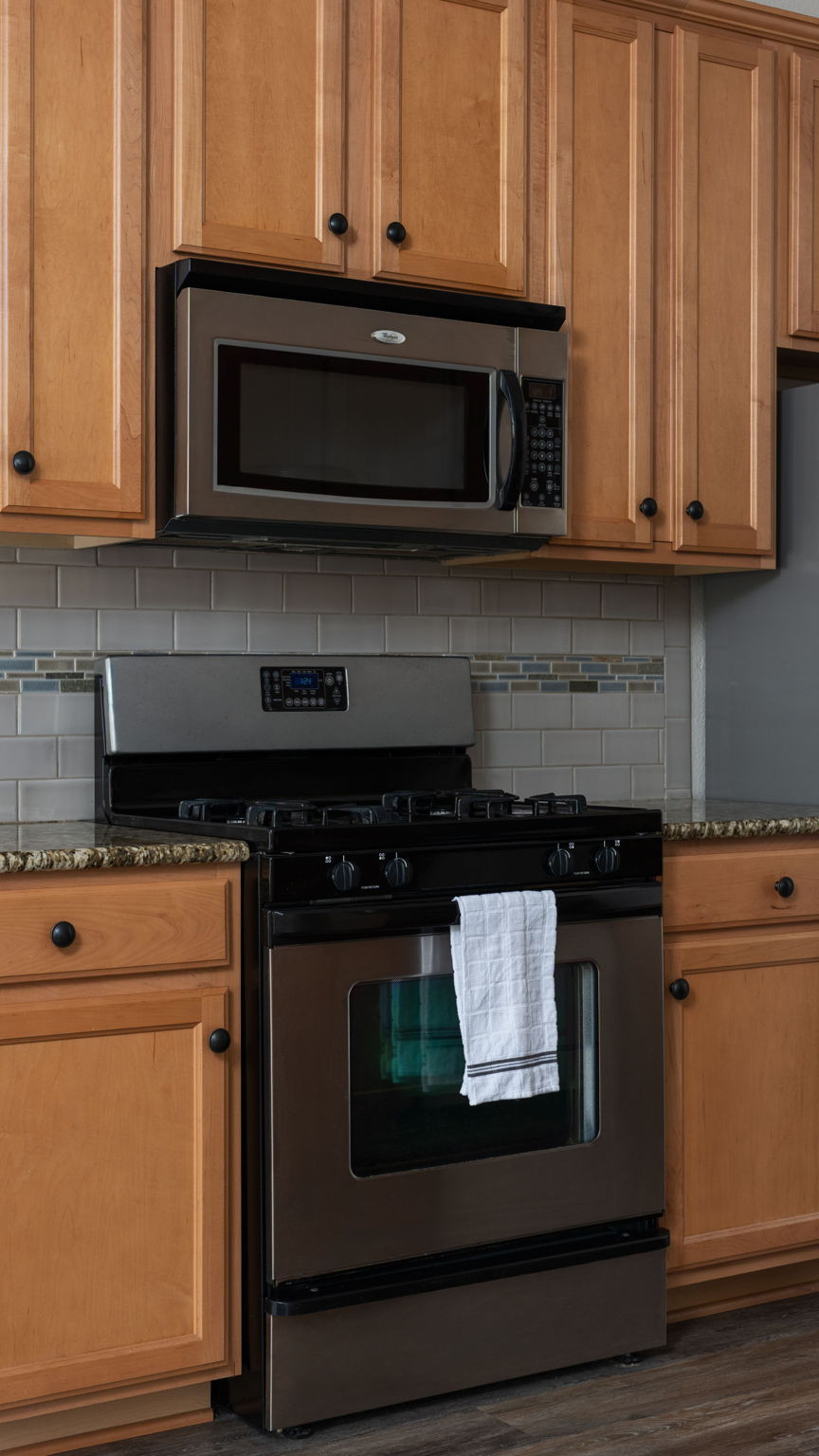 14815 Avery Ranch Boulevard, Unit 1401 Austin, TX 78717 - Photo 12 of 38 Stainless steel range with an overhead microwave oven, framed by light wood cabinetry with dark hardware