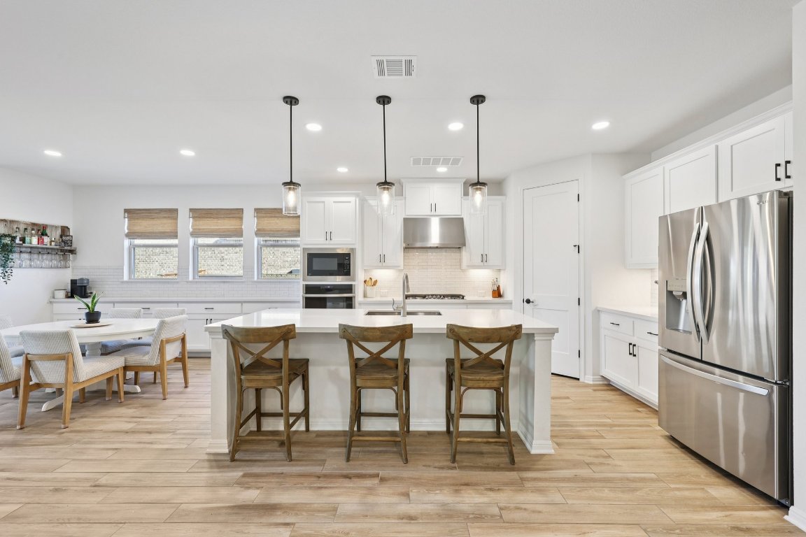 2913 Fallcrest Bend Leander, TX 78641 - Photo 13 of 40 a large kitchen with a table and chairs