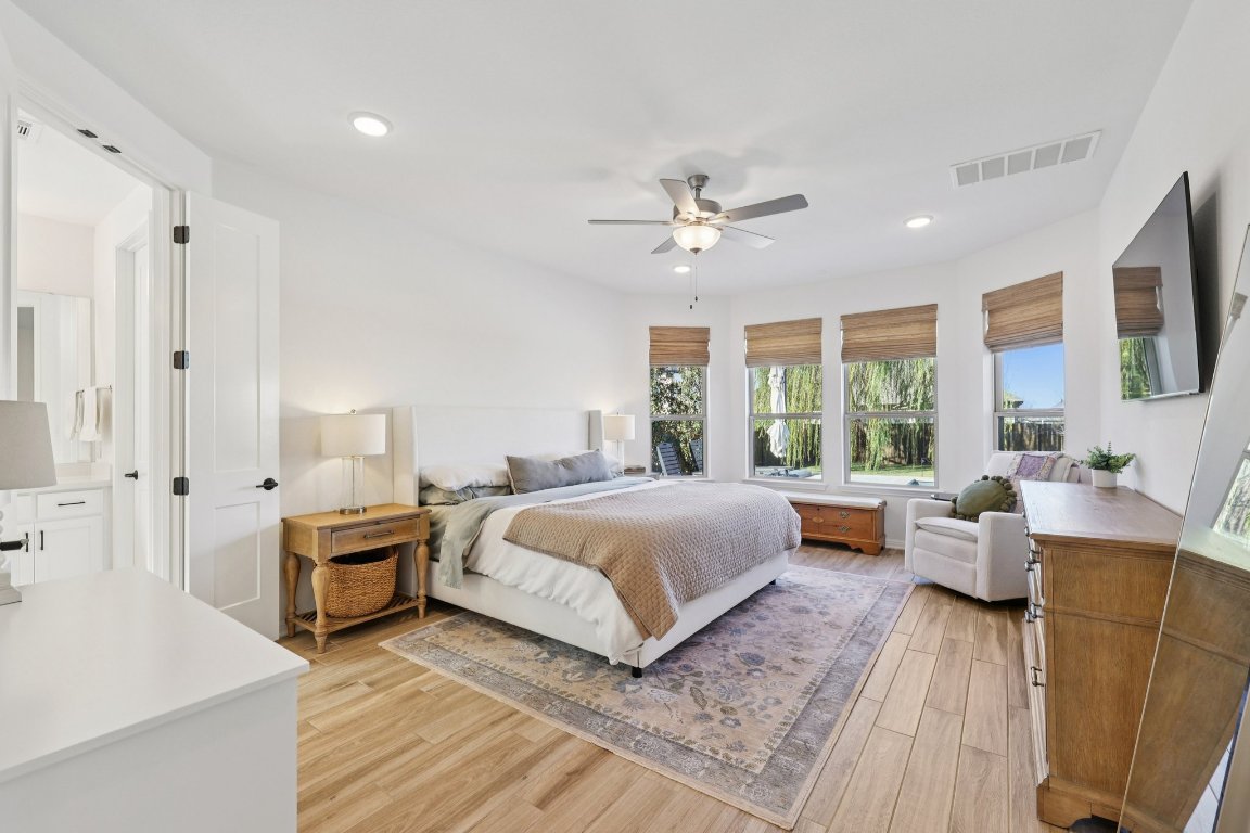 2913 Fallcrest Bend Leander, TX 78641 - Photo 15 of 40 a spacious bedroom with a large bed and a chandelier