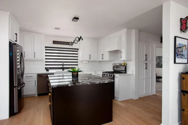 a kitchen with stainless steel appliances kitchen island granite countertop a refrigerator and a stove top oven