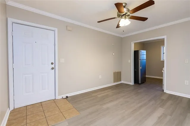 a view of an empty room with window and a ceiling fan