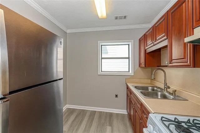 a kitchen that has a sink a refrigerator and window