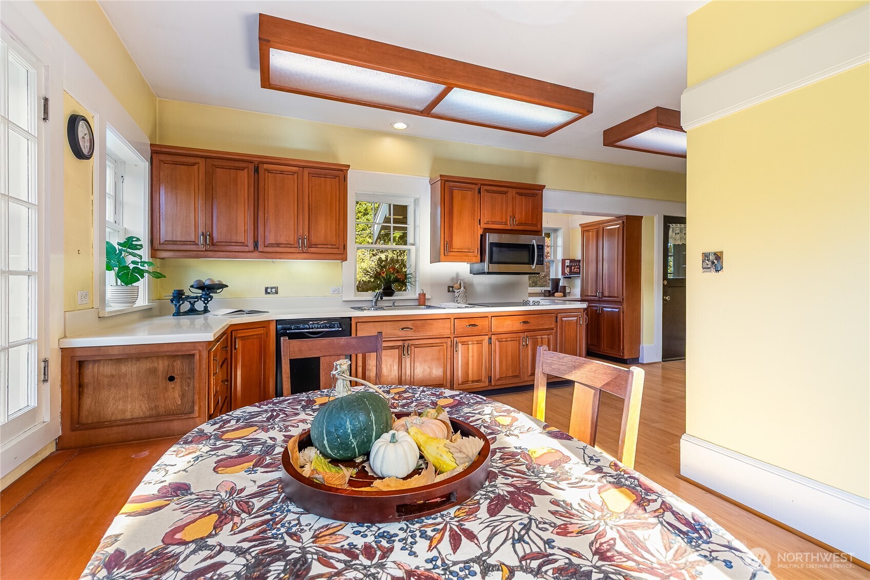 3905 Idaho Street Bellingham, WA 98229 - Photo 20 of 40 a kitchen with a stove a sink and a dining table with wooden floor
