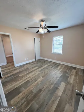 a view of a room with a ceiling fan and a window