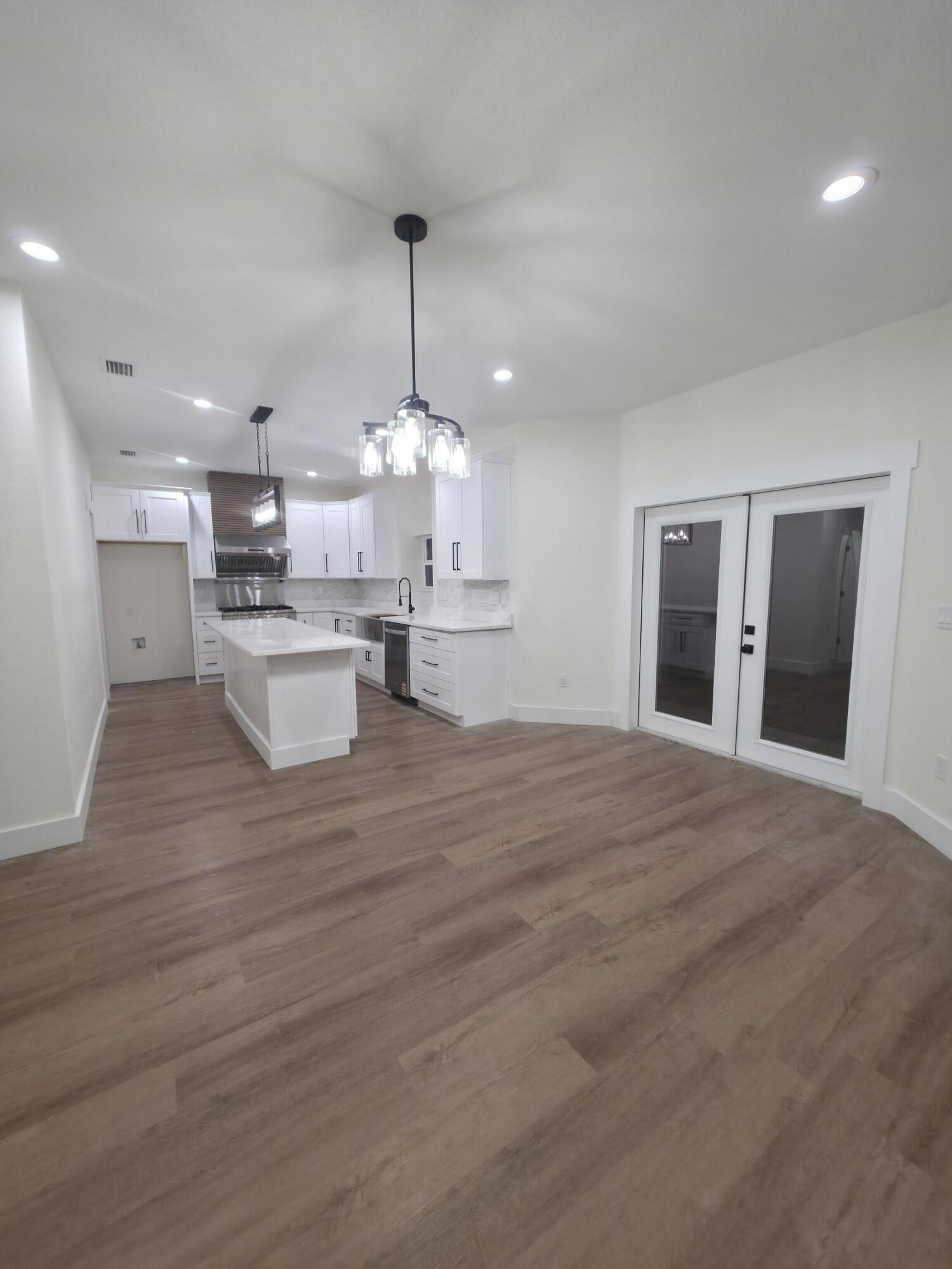 4699 Meadow Lake Drive Crestview, FL 32539 - Photo 14 of 38 a view of a kitchen with kitchen island stainless steel appliances a stove a sink dishwasher and a fireplace with wooden floor