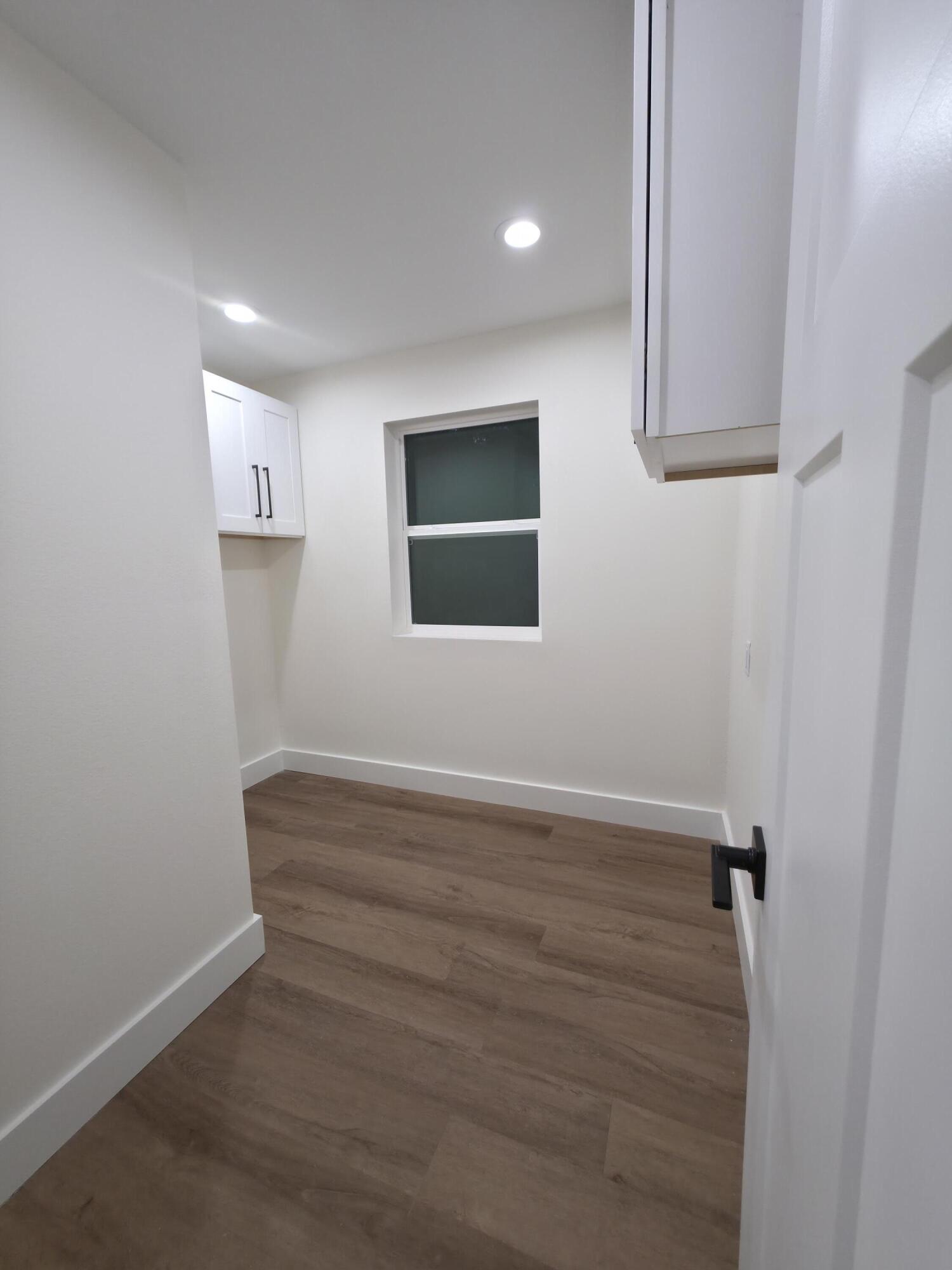 4699 Meadow Lake Drive Crestview, FL 32539 - Photo 20 of 38 a view of an empty room with wooden floor and a window