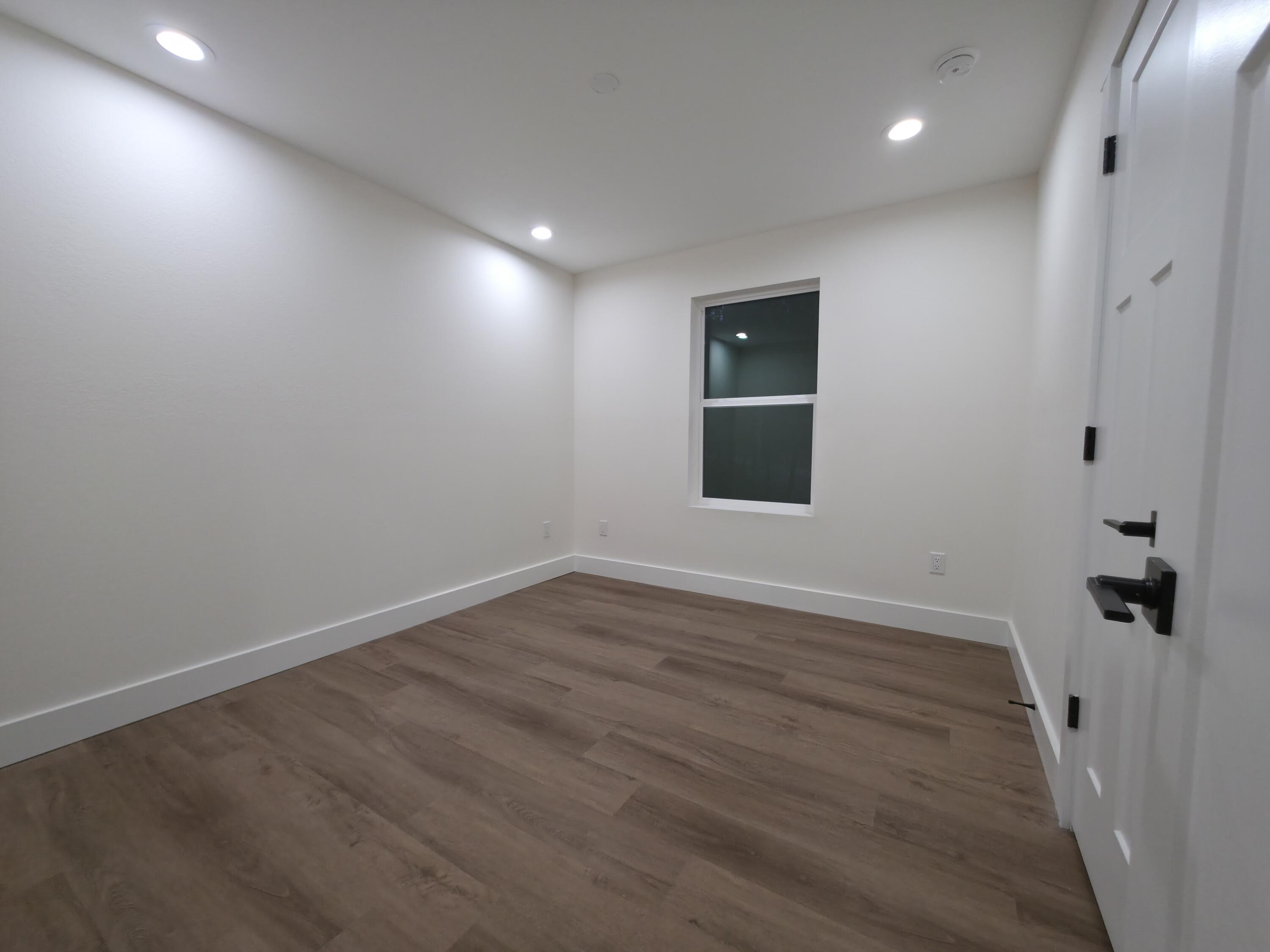 4699 Meadow Lake Drive Crestview, FL 32539 - Photo 21 of 38 an empty room with wooden floor and windows