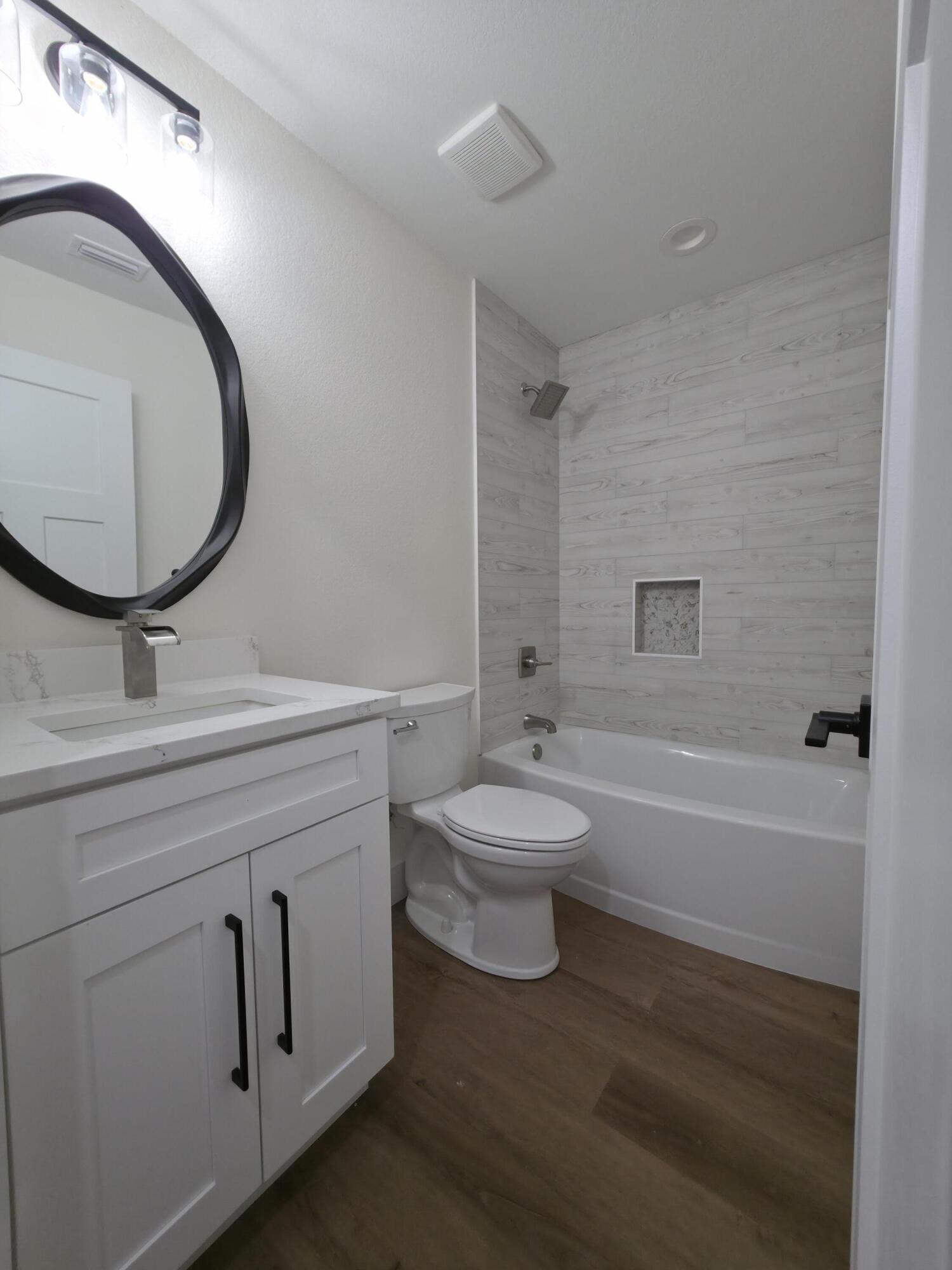 4699 Meadow Lake Drive Crestview, FL 32539 - Photo 26 of 38 a bathroom with a toilet sink vanity tub and mirror