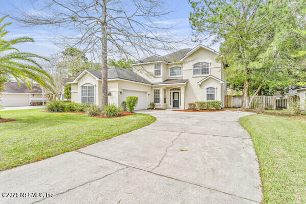 1896 Bluebonnet Way Fleming Island, FL 32003 - Photo 2 of 28 a front view of a house with a garden and trees