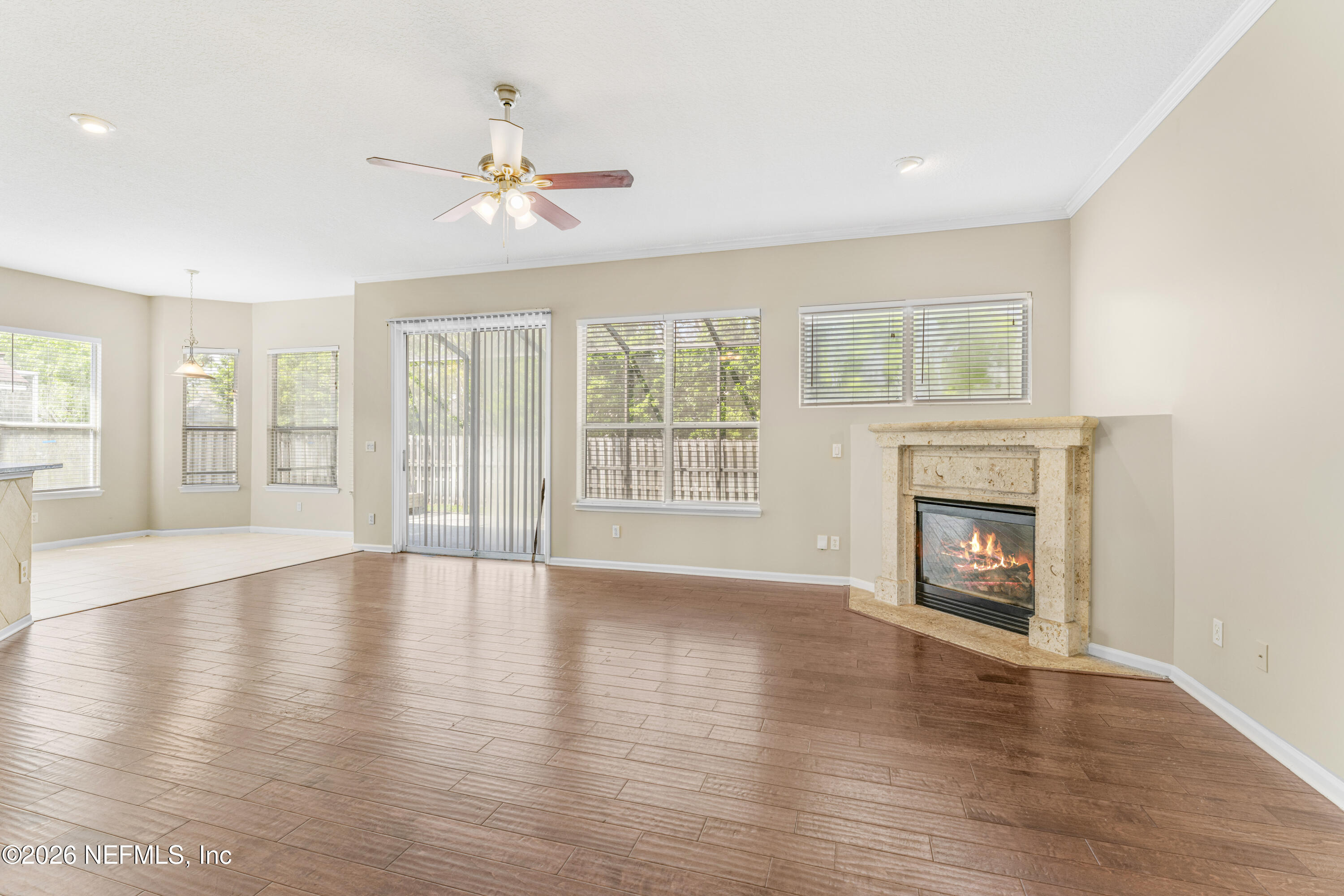 1896 Bluebonnet Way Fleming Island, FL 32003 - Photo 8 of 28 an empty room with wooden floor fireplace and windows