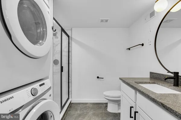 a bathroom with a granite countertop sink and a mirror