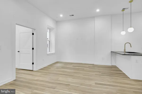 a view of a kitchen with white wooden cabinets and sink