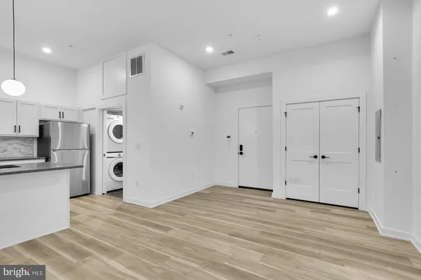 a view of a kitchen with a refrigerator and a stove top oven