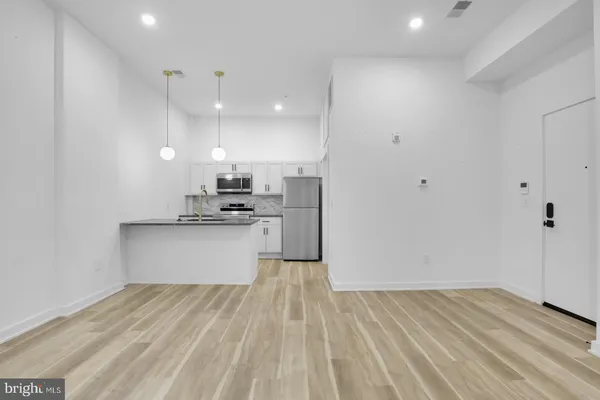 a view of kitchen with granite countertop cabinets and refrigerator