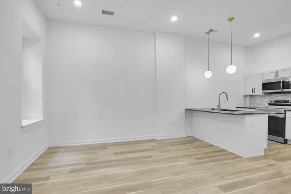 a kitchen with kitchen island a sink stainless steel appliances and cabinets