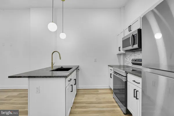 a kitchen with stainless steel appliances granite countertop a sink and a stove