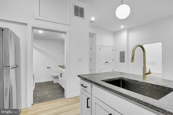 a bathroom with a granite countertop toilet sink and mirror