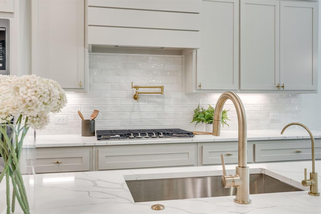 608 Tay Tay Way Springtown, TX 76082 - Photo 18 of 40 Sleek kitchen featuring light cabinetry, a white subway tile backsplash, a gas range with a pot filler, and a deep undermount sink with a gooseneck faucet