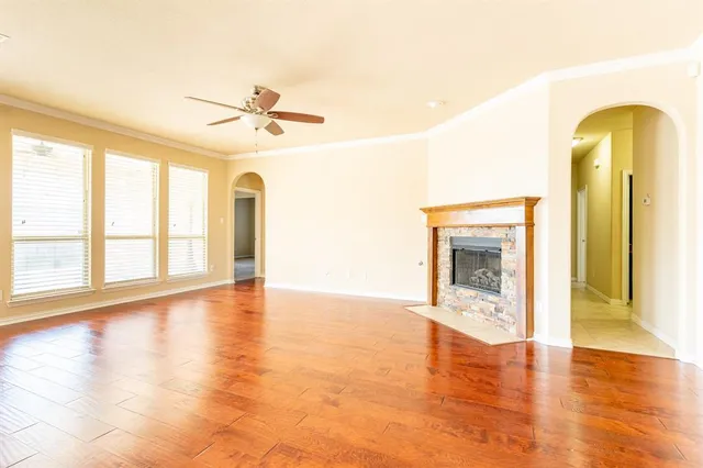 a view of an empty room with a window and wooden floor