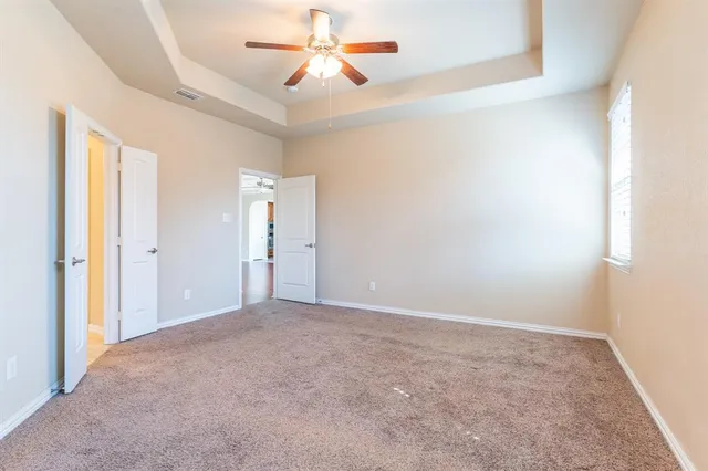 an empty room with closet and a chandelier fan