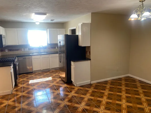 a kitchen with stainless steel appliances granite countertop a stove a sink and a refrigerator