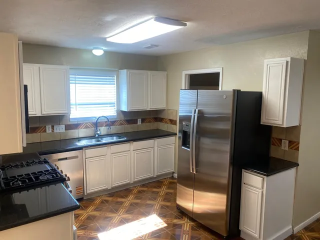 a kitchen with a sink a stove and cabinets