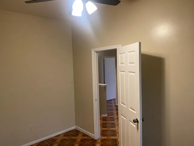 an empty room with a window and a fan