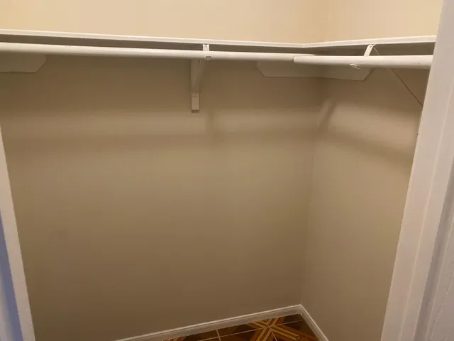 a white toilet sitting next to a white wall