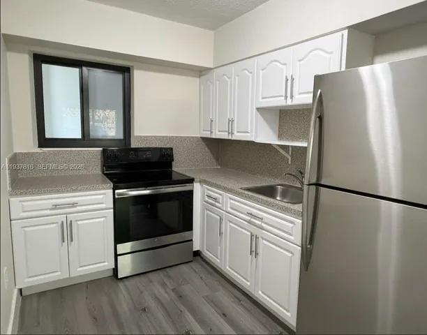 a kitchen with white cabinets and white appliances