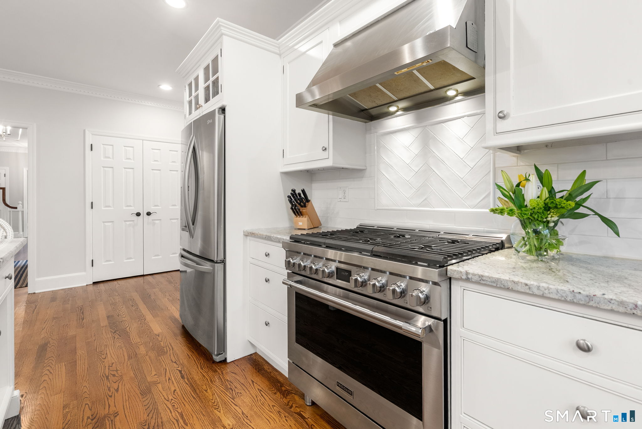 9 Pepperbush Road Weston, CT 06883 - Photo 12 of 48 a kitchen with stainless steel appliances a stove a refrigerator and a wooden floor