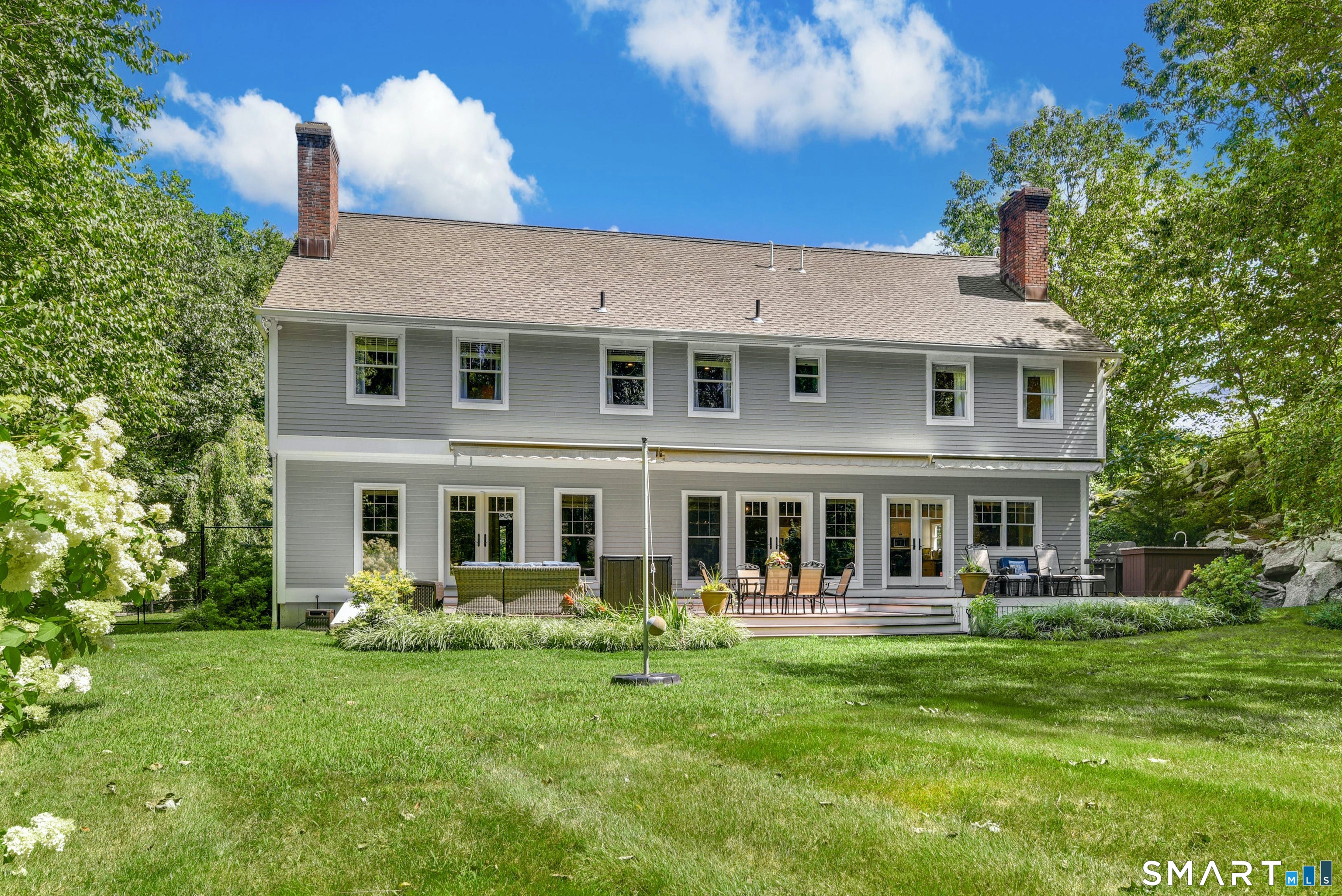 9 Pepperbush Road Weston, CT 06883 - Photo 6 of 48 a front view of a house with a yard table and chairs