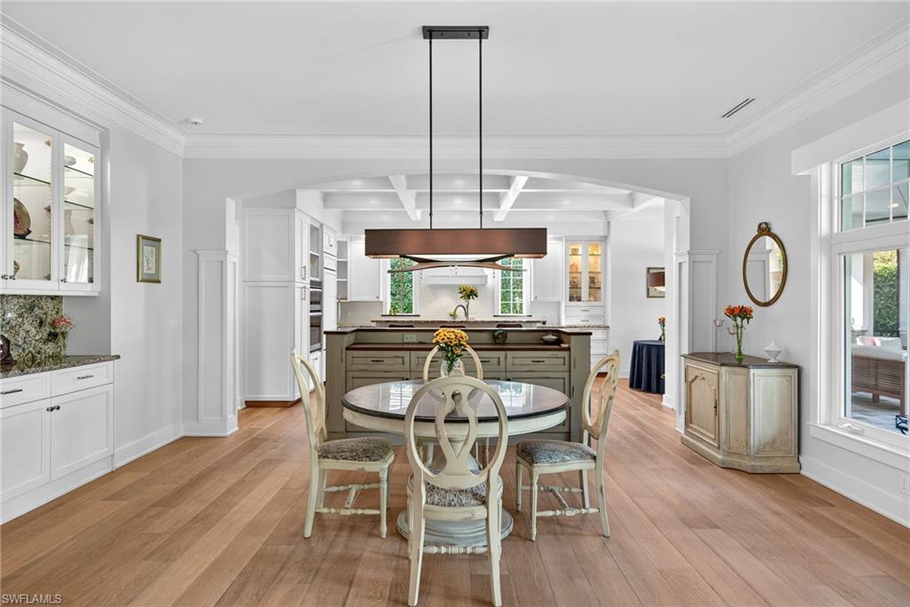 2305 Harrier Run Naples, FL 34105 - Photo 13 of 50 a dining room with furniture a chandelier and wooden floor