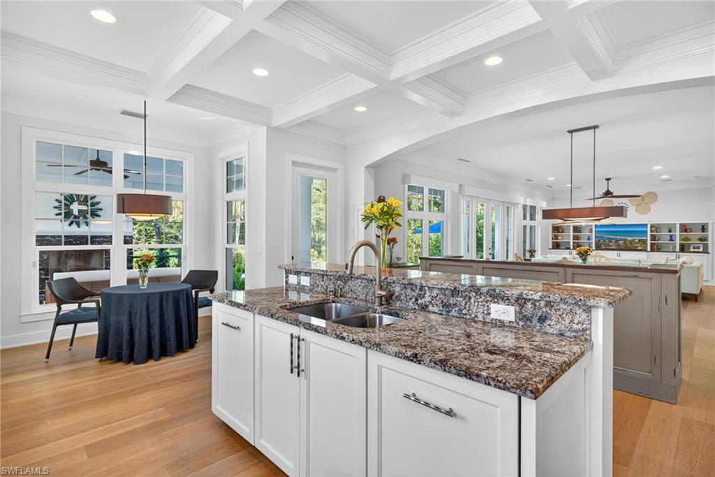 2305 Harrier Run Naples, FL 34105 - Photo 19 of 50 a kitchen with stainless steel appliances granite countertop a sink and wooden floor